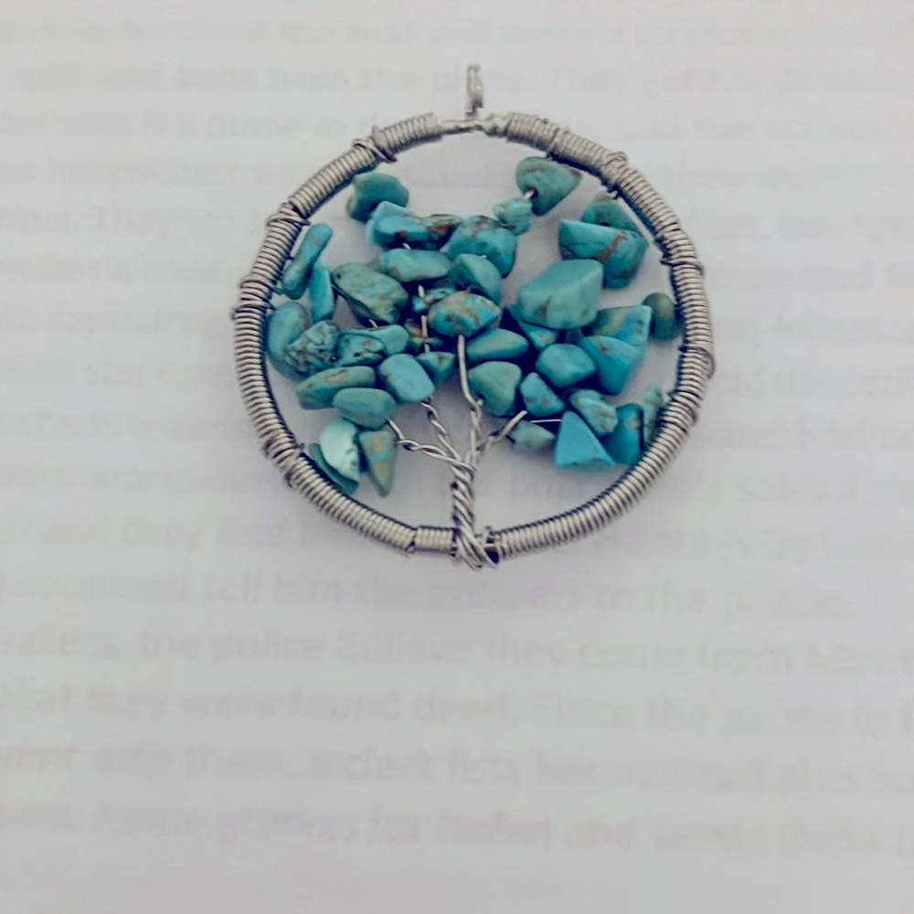 Silver tone ‘Tree of Life’ pendant with turquoise color stone leaves.